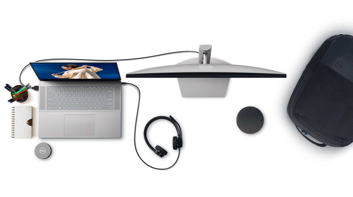 Photo d’un ordinateur portable Dell avec casque et écran connectés, sac à dos, adaptateur mobile et haut-parleur, vu de dessus.
