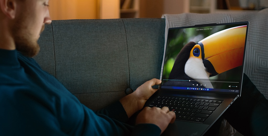 Person on a couch watching a video on the Lenovo ThinkPad Z16 laptop.
