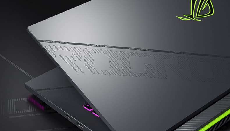 Le couvercle de l'ordinateur portable est montré, avec le motif ROG et la barre oblique reflétant la lumière environnante.
